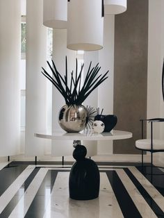 a black and white striped floor with vases on the table in front of it