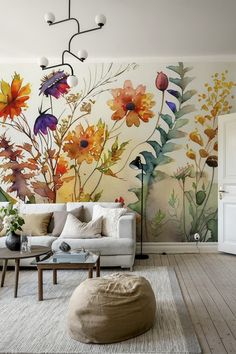 the living room is decorated with colorful flowers and plants on the wall, along with a bean bag ottoman