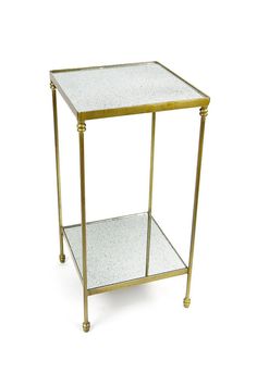 a gold metal and glass side table with two shelves on each side, against a white background