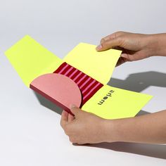 a person is holding a piece of paper with sticky notes attached to it, while another hand holds the post - it note