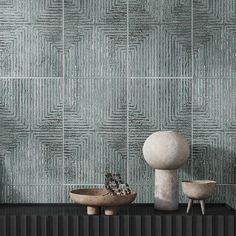 a bathroom with two stone sinks and a large wall tile pattern on the wall behind it