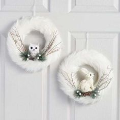 two white wreaths with owls and pine cones