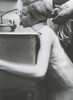 a little boy is getting his hair brushed by an adult in the kitchen sink,