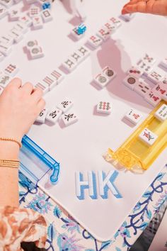 two people playing a board game with letters and dices on the table next to each other