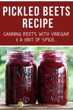 two jars filled with pickled beets sitting on top of a wooden table