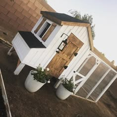 a small white house with two potted plants