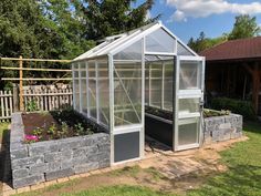 a small greenhouse in the middle of a yard