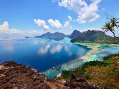 an island surrounded by blue water and mountains