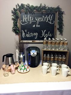 there is a coffee bar with cups on the counter and a sign above it that says help yourself at the watering hole