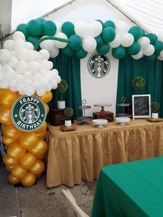 the table is set up with balloons and starbucks signs on it, along with other decorations