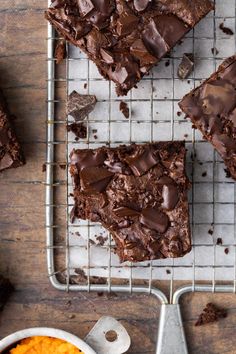 chocolate brownies on a cooling rack with spoons and bowl of mashed potatoes