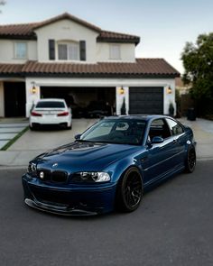 a blue car parked in front of a house