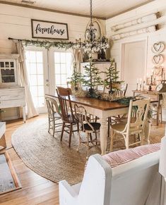 a dining room table with chairs and a christmas tree in the center surrounded by wreaths