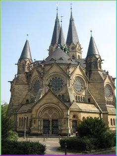 an old church with towers and clocks on the front