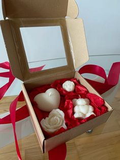 an open box with soaps inside on a wooden floor next to ribbons and ribbon