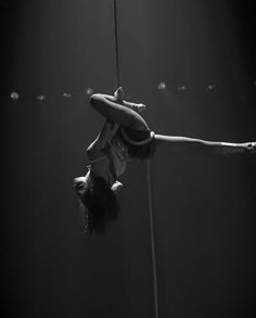 a woman hanging upside down on a rope