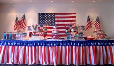 an american flag themed dessert table with red, white and blue decorations on the table