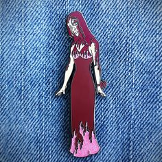 a pin with a woman in a red dress on it