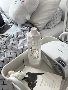 an open laptop computer sitting on top of a bed next to a bottle of water