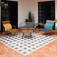 three chairs and a table sitting on top of a tiled floor