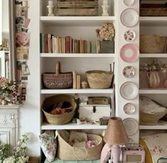 a living room filled with lots of furniture and bookshelves covered in pink plates