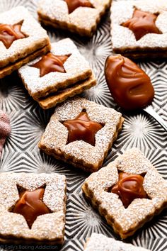 cookies with chocolate frosting and star decorations on a glass platter, ready to be eaten