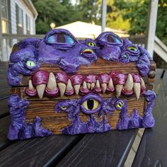 a purple box with teeth and fangs on it sitting on a table outside in front of a house