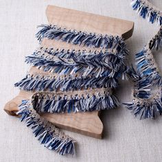 several pieces of blue and white yarn on a wooden board