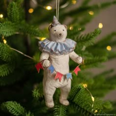 a teddy bear ornament hanging from a christmas tree