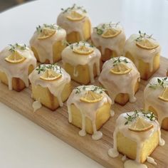 a wooden tray topped with lemon cakes covered in icing