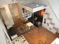 an aerial view of a living room and dining area from the top floor, looking down