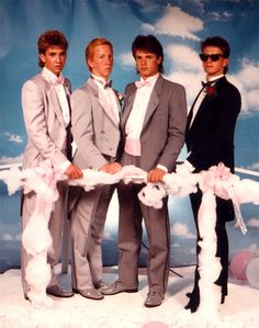 three men in suits and ties are standing next to each other