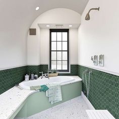 a bath room with a large tub and a window