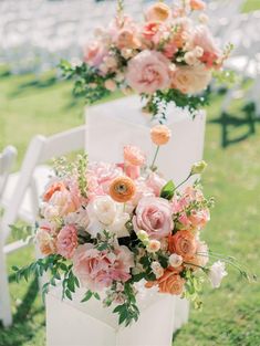 two white chairs with pink and orange flowers on them