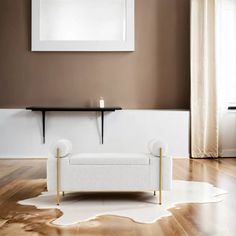 a white couch sitting on top of a hard wood floor next to a wall mounted mirror