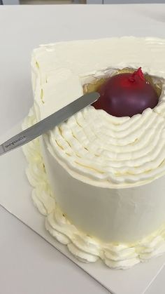 a knife cutting into a cake with white frosting