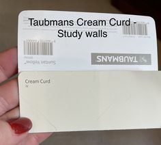 a person holding up a white card with the words saunans cream curl study walls on it