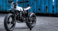 a motorcycle parked in front of a blue container