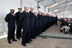 a group of men in navy uniforms standing next to each other