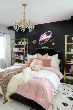 a bedroom decorated in pink and black with a neon sign on the wall above the bed