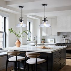 a kitchen island with three stools next to it