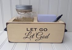 a wooden box with writing on it that says let go let god in front of a mason jar