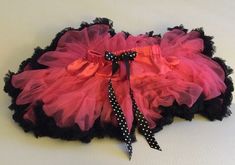 a pink and black tutu skirt with polka dots on the bottom, attached to a white background