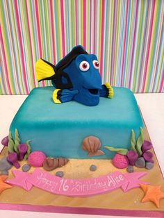 a birthday cake with an image of a blue fish on the front and bottom layer