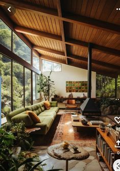 a living room filled with lots of furniture next to a window covered in plants and trees