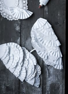 several white doily are laid out on a wooden table with an empty bottle next to them