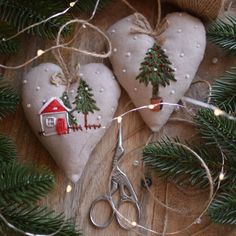 two heart shaped ornaments are sitting on a wooden table with christmas lights and twine