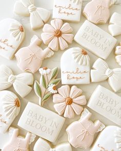 baby in bloom cookies are arranged on a table with white and pink icing,