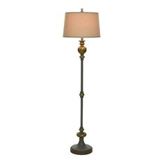 a floor lamp with a beige shade on it's side and a white background