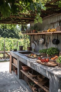 an outdoor kitchen with pots and pans hanging from the ceiling, surrounded by greenery